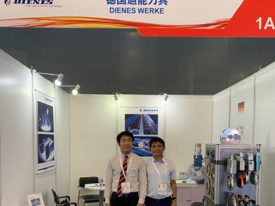 The picture shows the DIENES booth at the ANEX-SINCE 2021 and two employees.