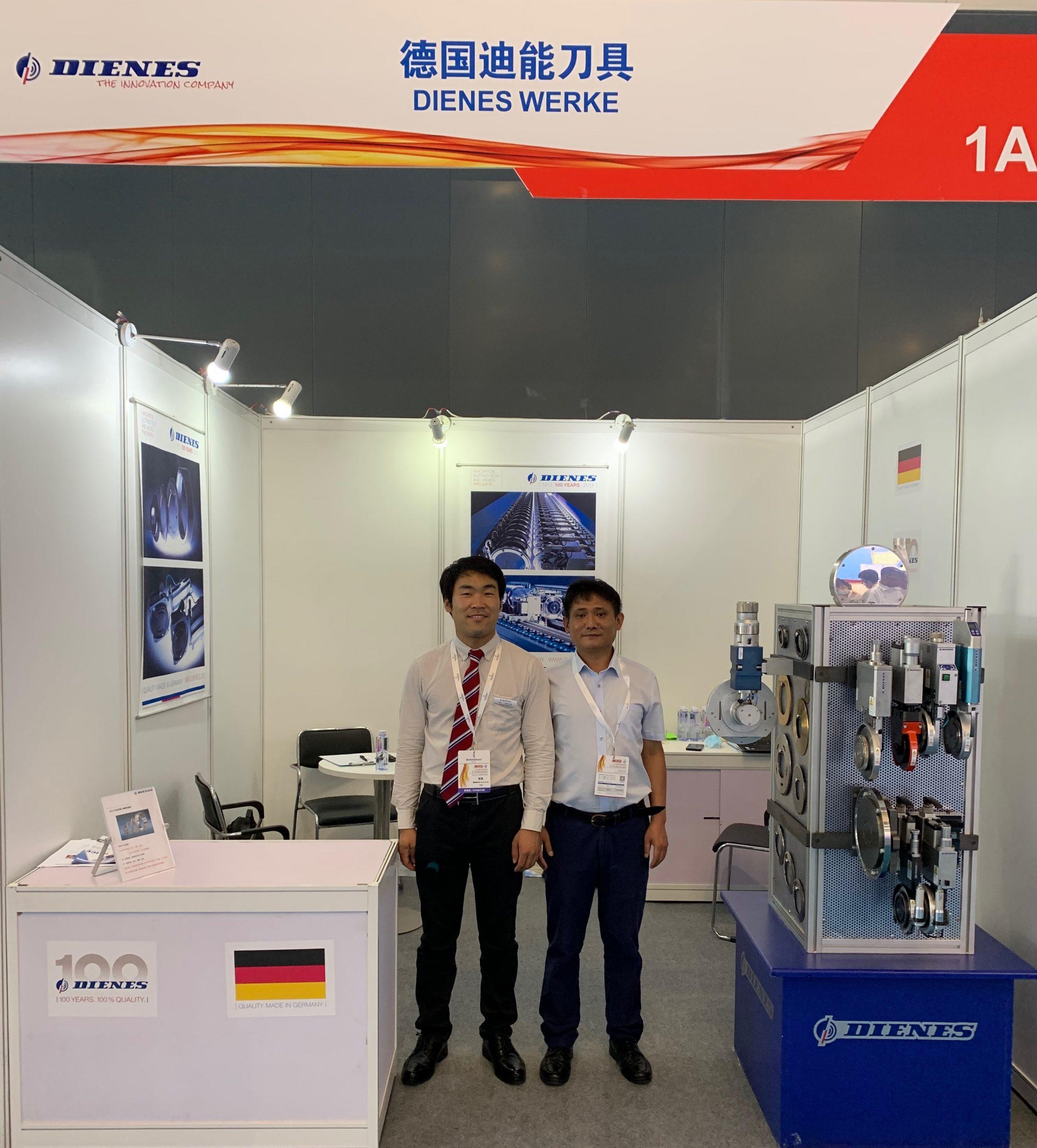 The picture shows the DIENES booth at the ANEX-SINCE 2021 and two employees.